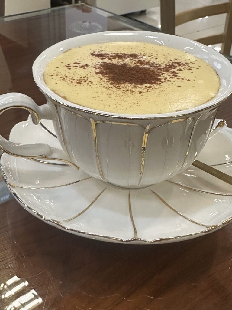 Vietnamese egg coffee served at Hanoi airport in a decorative ceramic cup.